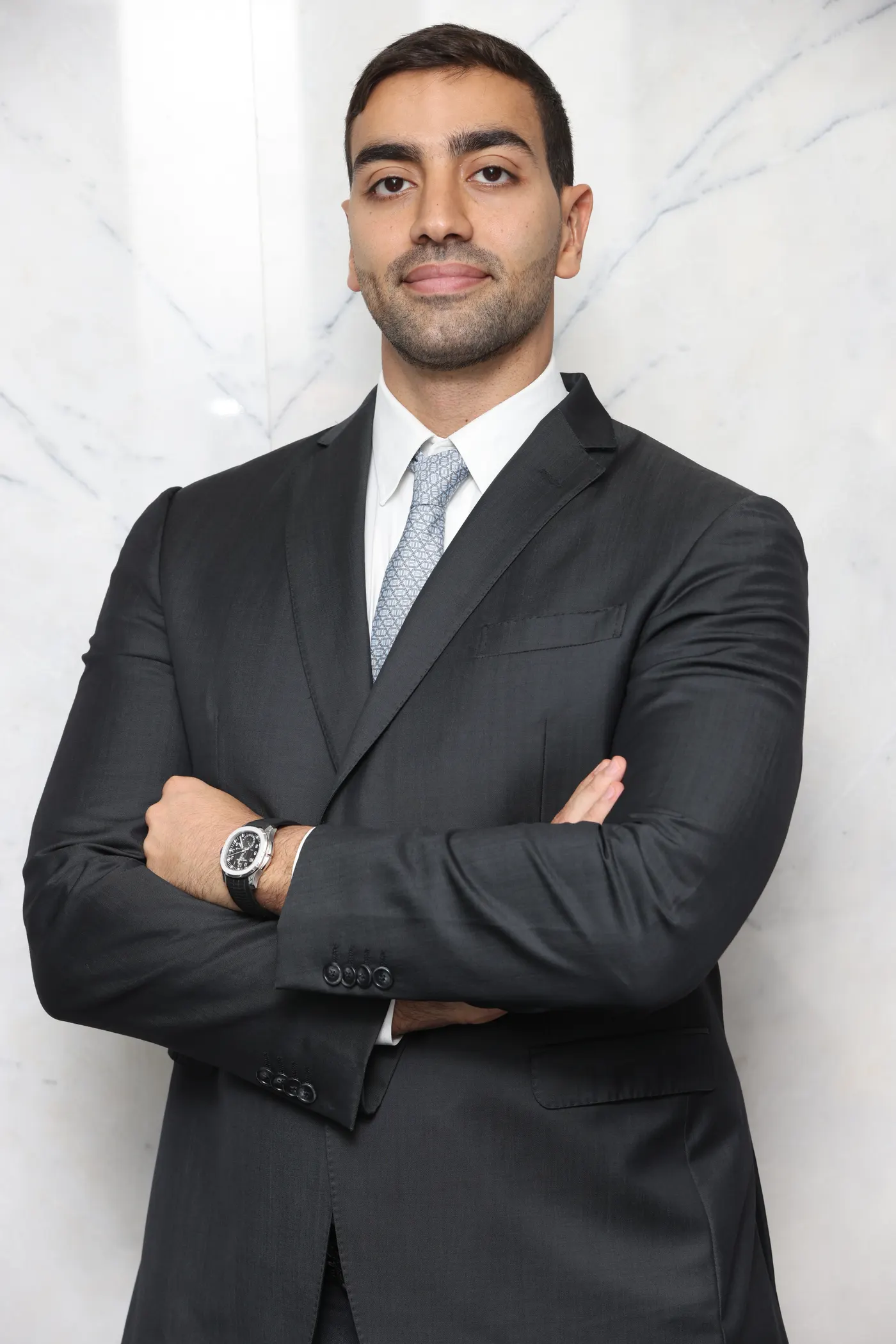 Portrait of Samuel Saba, arms folded, in a dark suit